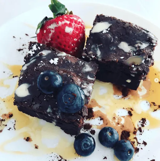 Chocolate brownies with a strawberry and blueberries